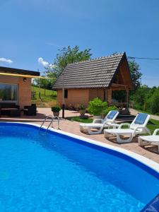 a swimming pool with chairs and a house at Koliba La Perla in Banja Luka +17 photos
