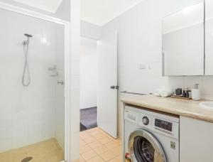 a kitchen with a washing machine in a bathroom at Whale Stay in Tathra