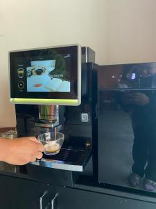 a person is putting a bowl in a coffee machine at Hotel De Nara in Chiang Mai +239 photos