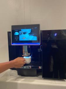 a person is holding the screen of a coffee machine at The Guest Chang Moi Boutique Hotel in Chiang Mai