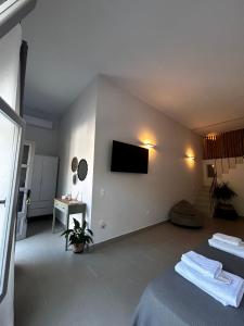 a room with two beds and a tv on the wall at Mezzo Patmos Apartments in Patmos