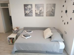 a bed in a bedroom with three paintings on the wall at Ka6 Infinity Apartment - Vipava Valley in Ajdovščina