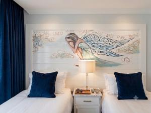 a bedroom with two beds with a painting on the wall at Be Our Guest Self Catering in Nelspruit