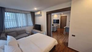 a hotel room with a bed and a couch at Stasia Suites Sriracha in Ban Fang Daeng +47 photos
