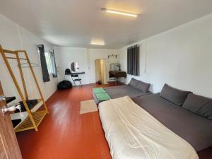 a bedroom with a bed and a couch in it at 3199 Cafe' Latya & Bed in Ban Lum Makok