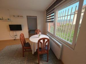 a table and chairs in a room with a window at Close to SCC Luxury apartment in Sarajevo in Sarajevo