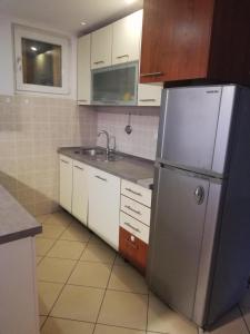 a kitchen with a stainless steel refrigerator and white cabinets at Close to SCC Luxury apartment in Sarajevo in Sarajevo