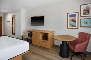 a room with a bed and a table and a tv at Hampton Inn by Hilton Odessa in Odessa