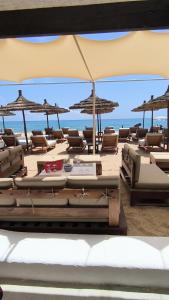 a bunch of lounge chairs and umbrellas on a beach at kabila vista vuestra a la piscina Z6 in Martil