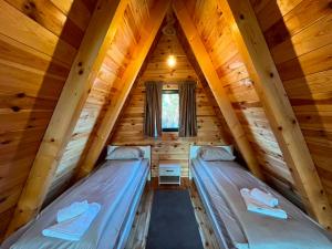 two beds in a room in a log cabin at Golden Horizon in Žabljak