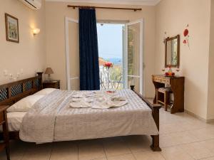 a bedroom with a bed and a window with a view at Des Roses Hotel in Platanias