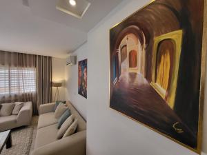 a living room with a large painting on the wall at Luxuary pool appartement in La Marsa