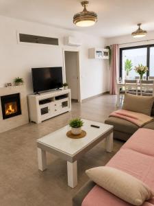 a living room with a couch and a table and a tv at Pozo, 22 in Fuente Palmera