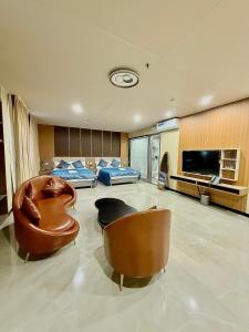 a large living room with two chairs and a television at Skyport Hotel in Manila