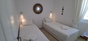 two beds in a room with a mirror on the wall at Naxian Scenery in Glinado Naxos