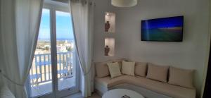 a white living room with a couch and a balcony at Naxian Scenery in Glinado Naxos