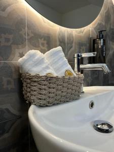 a basket of towels sitting on top of a bathroom sink at PIAZZADUOMO b&b Stilo in Stilo