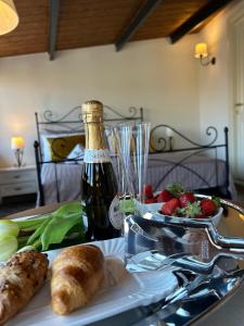 a table with a bottle of wine and a plate of food at PIAZZADUOMO b&b Stilo in Stilo