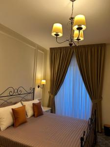 a bedroom with a bed with a chandelier and a window at PIAZZADUOMO b&b Stilo in Stilo +14 photos