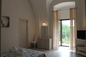 a bedroom with a bed and a sliding glass door at B&B La Taverna in Campodimele