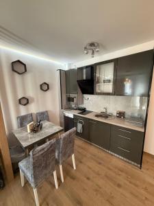 a kitchen with a table and chairs in a room at Aurora Lux Wellness & Spa in Veliko Gradište