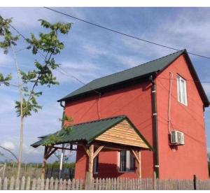 a red barn with a fence in front of it at Natali & Giga in Ureki