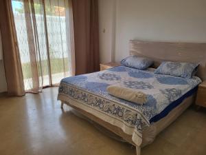 a bedroom with a bed with a blue comforter and pillows at Luxuary pool appartement in La Marsa +36 photos