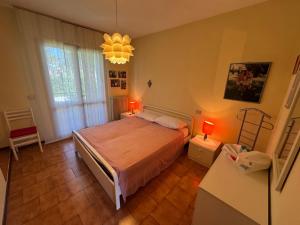 a bedroom with a bed and a chandelier at Villa Dosso Fiorito in Lignano Sabbiadoro