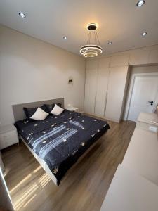 a bedroom with a bed with a blue comforter at Tamerlane Premium Apartment in Samarkand