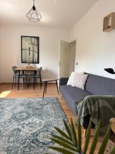a living room with a blue couch and a table at WeLiving Apartments in Weinheim