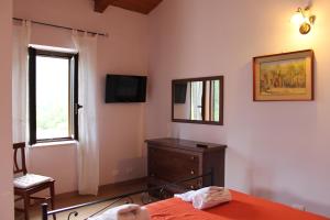a bedroom with a bed and a dresser and a window at B&B La Taverna in Campodimele