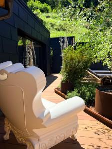 Ein weißes Sofa steht auf einer Terrasse mit Pflanzen. in der Unterkunft Hotel Folgarida in Folgarida