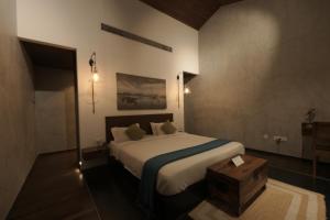 a bedroom with a large bed and a wooden table at 976 Panangad in Cochin