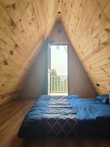 a bed in a room with a large window at The jungle tales in Bhīm Tāl