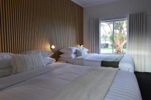 two beds in a hotel room with a window at Sea Lake Motel-24 Hour Check-In Private Ensuite Rooms in Sea Lake