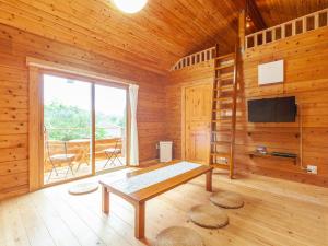 a living room with a table and a television in a cabin at 石垣島コテージAkeeesi365 LOG in Ishigaki Island