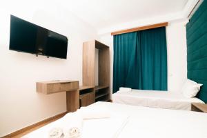 a hotel room with two beds and a flat screen tv at Hotel Dajti in Ulcinj