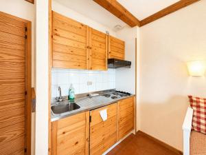 a kitchen with wooden cabinets and a sink at Hostdomus - A3-24 in Grange Sises