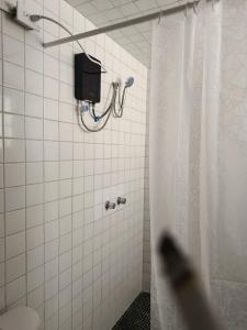a white tiled bathroom with a shower curtain at Studio Azul in Tlaxcala de Xicohténcatl