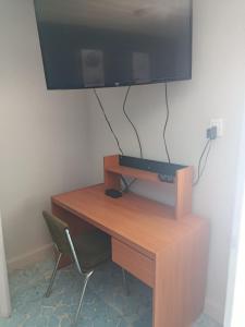 a desk with a television on a wall with a chair at Studio Azul in Tlaxcala de Xicohténcatl