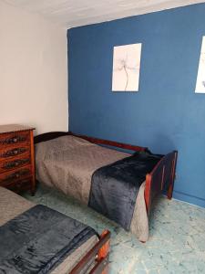 a bedroom with two beds and a blue wall at Studio Azul in Tlaxcala de Xicohténcatl