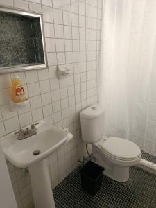 a bathroom with a white toilet and a sink at Studio Azul in Tlaxcala de Xicohténcatl