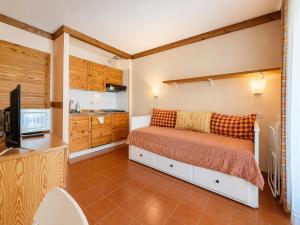 a small bedroom with a bed and a kitchen at Hostdomus - A3-24 in Grange Sises +4 photos