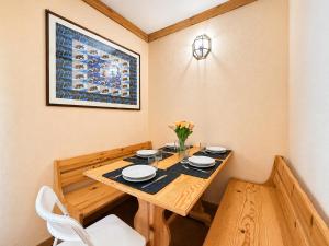 a dining room with a wooden table and white chairs at Hostdomus - A3-24 in Grange Sises