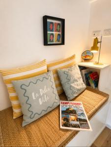 a bed with two pillows and a book at Casa Lebirann in Bacoli