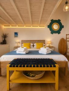 a bedroom with a large bed with a yellow bench at Casa Lebirann in Bacoli