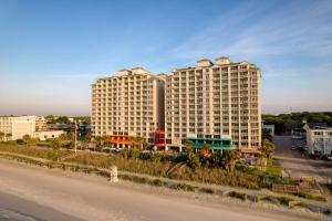 a large white building on the side of a road at Hampton Inn & Suites Myrtle Beach Oceanfront in Myrtle Beach