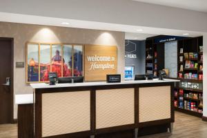 a welcome to hampton inn and suites lobby with a counter at Hampton Inn & Suites - DeLand in De Land