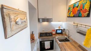 a small kitchen with a stove and a microwave at Casa Lebirann in Bacoli +17 photos