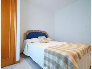 a bedroom with a bed with a blanket on it at GALIHOST - Casa Chouba, frente a la playa in Sanxenxo
